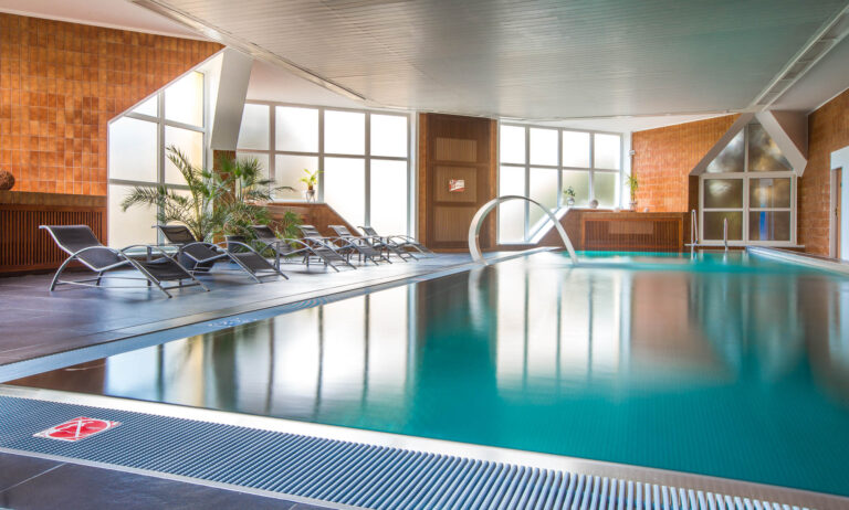 vnitřní bazén s chrličem s lehátky